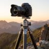 凍てつく山頂の岩場で雲海を前に立つLeofotoサミットシリーズ三脚(LM-364C)とカメラ
